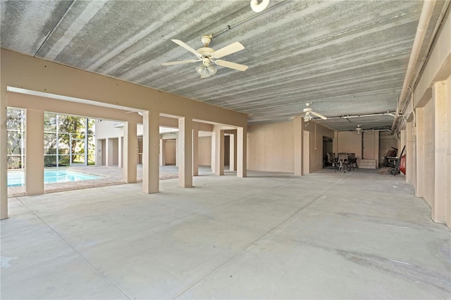 interior space featuring a ceiling fan and concrete floors