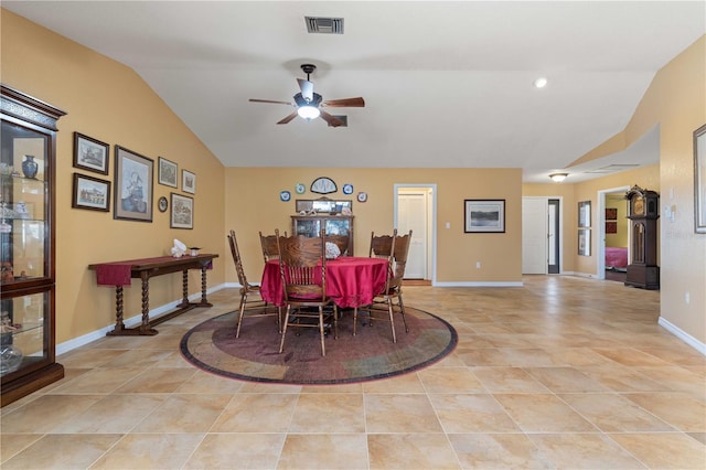 dining area featuring light tile patterned flooring, a ceiling fan, visible vents, vaulted ceiling, and baseboards