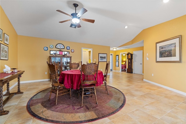 dining space with vaulted ceiling, light tile patterned floors, a ceiling fan, and baseboards