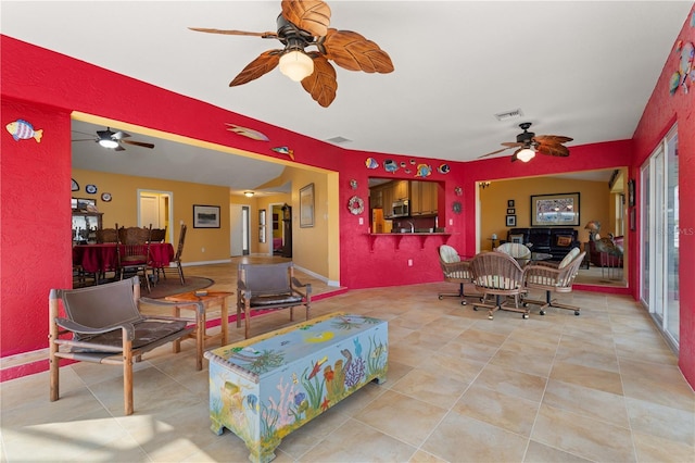 tiled living area with a ceiling fan, visible vents, and baseboards