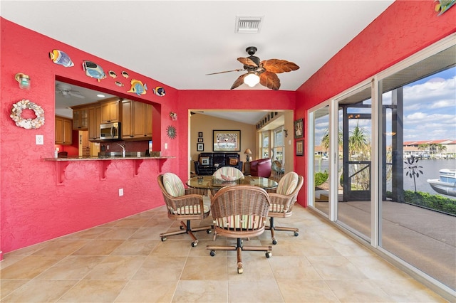dining room with visible vents, a ceiling fan, and a textured wall