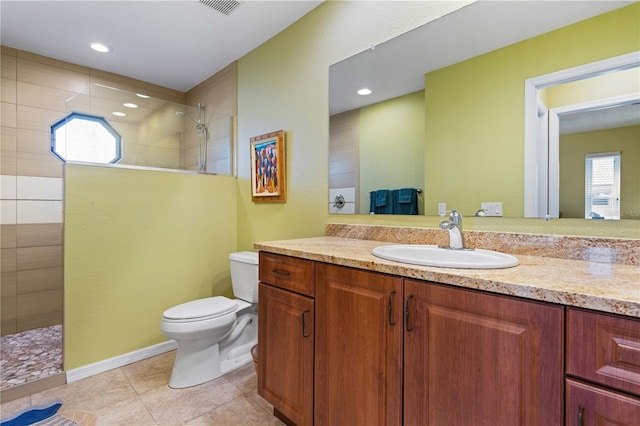 bathroom with tile patterned floors, vanity, toilet, and walk in shower