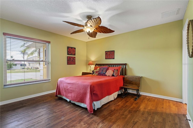 bedroom with wood finished floors, visible vents, and baseboards
