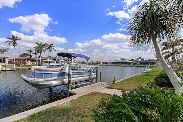 dock area featuring a water view, boat lift, a residential view, and a lawn
