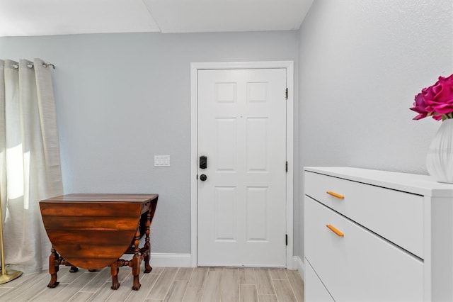 entryway with baseboards and wood tiled floor