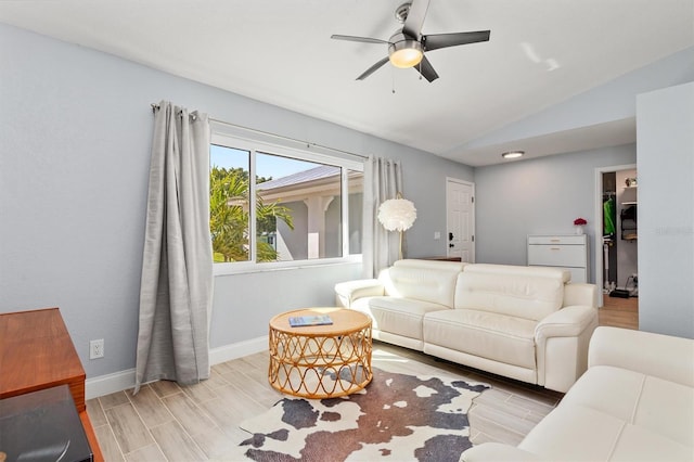 living area with lofted ceiling, ceiling fan, baseboards, and wood finish floors