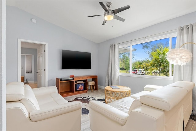 living area with ceiling fan, vaulted ceiling, and light wood-style flooring