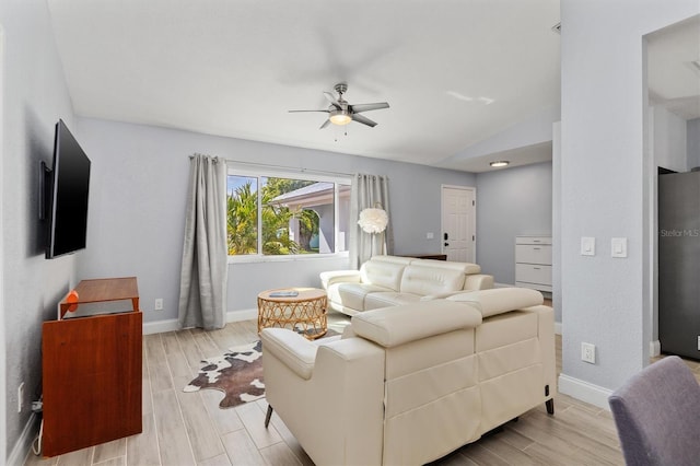 living room featuring lofted ceiling, wood tiled floor, baseboards, and a ceiling fan