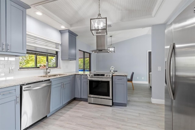 kitchen with island range hood, a peninsula, an inviting chandelier, vaulted ceiling, and stainless steel appliances