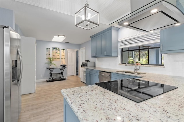 kitchen with a sink, stainless steel appliances, light wood-type flooring, blue cabinetry, and backsplash