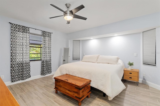 bedroom with wood tiled floor, ceiling fan, and baseboards