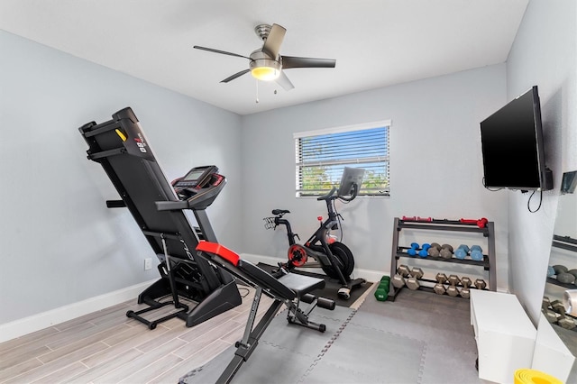 exercise room with ceiling fan, baseboards, and wood finished floors