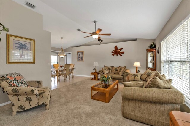 living room featuring ceiling fan, visible vents, vaulted ceiling, and carpet flooring