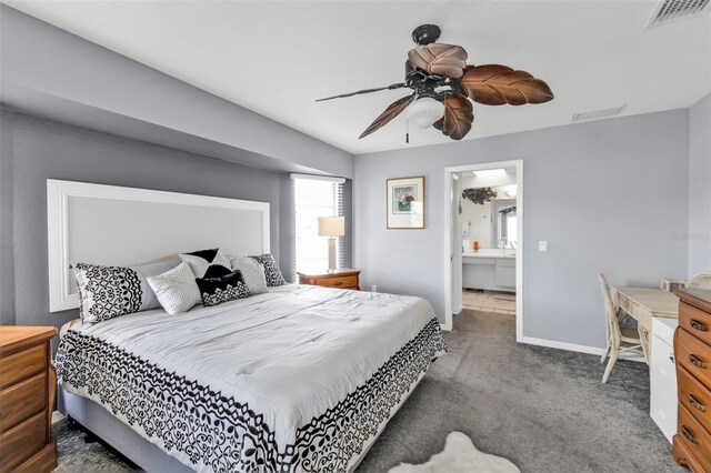 carpeted bedroom featuring ensuite bath, baseboards, visible vents, and ceiling fan