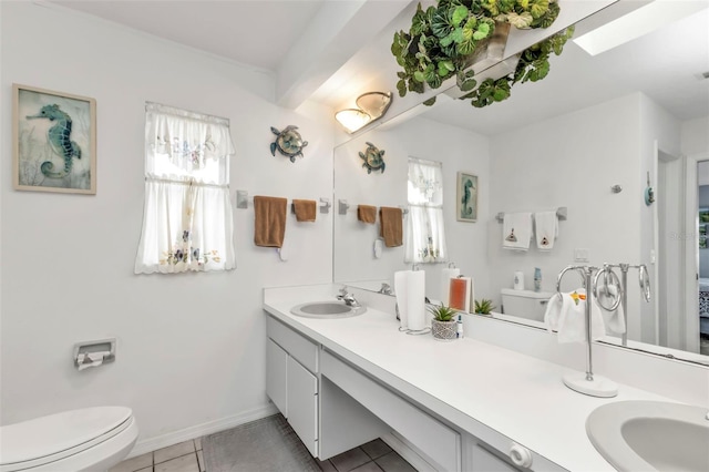 ensuite bathroom featuring toilet, ensuite bathroom, vanity, baseboards, and tile patterned floors