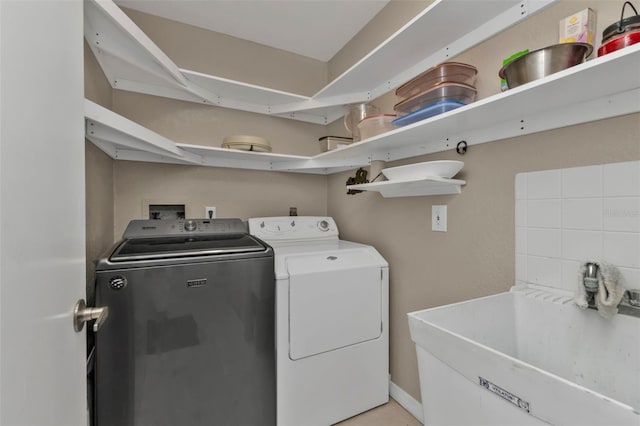 laundry room featuring laundry area, washer and clothes dryer, and a sink