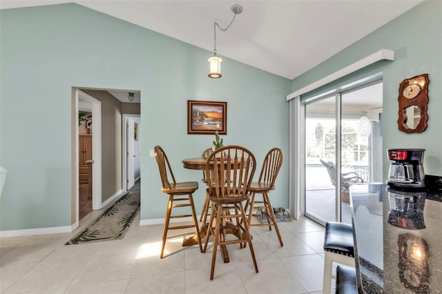 dining area with light tile patterned flooring, vaulted ceiling, and baseboards