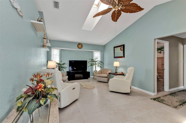 living room with a skylight, light tile patterned floors, baseboards, visible vents, and a ceiling fan