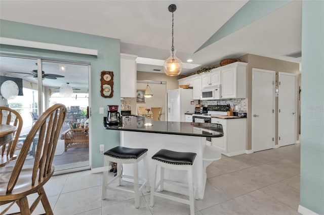 kitchen featuring white appliances, white cabinets, vaulted ceiling, tasteful backsplash, and dark countertops