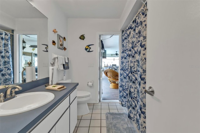 bathroom with toilet, curtained shower, tile patterned flooring, and vanity