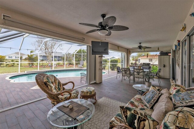 view of patio / terrace with ceiling fan, glass enclosure, an outdoor living space, and an outdoor pool