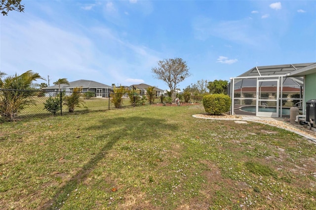 view of yard with glass enclosure, fence, and an outdoor pool