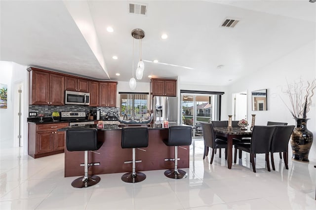 20339 Gentry Ave, Port Charlotte, FL 33952 - kitchen with appliances with stainless steel finishes, dark countertops, visible vents, and a breakfast bar