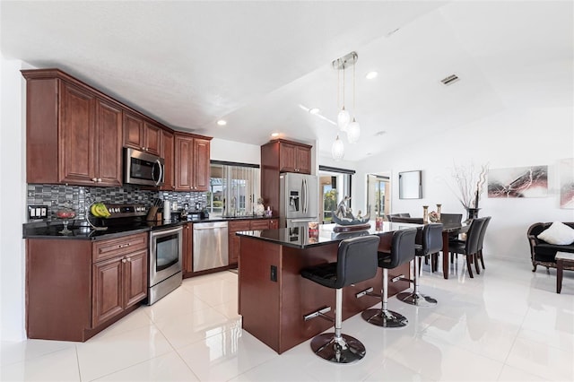 20339 Gentry Ave, Port Charlotte, FL 33952 - kitchen featuring dark countertops, a breakfast bar, vaulted ceiling, and appliances with stainless steel finishes