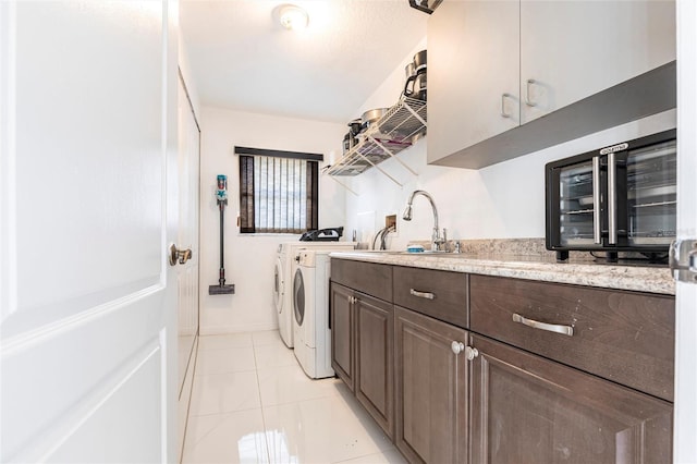 20339 Gentry Ave, Port Charlotte, FL 33952 - laundry area with light tile patterned floors, a sink, beverage cooler, cabinet space, and washer and clothes dryer
