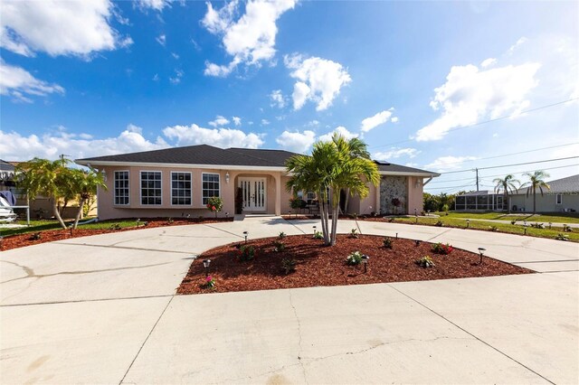 20339 Gentry Ave, Port Charlotte, FL 33952 - single story home featuring french doors, stucco siding, and curved driveway
