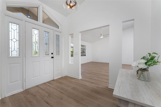 foyer featuring high vaulted ceiling, baseboards, and wood finished floors