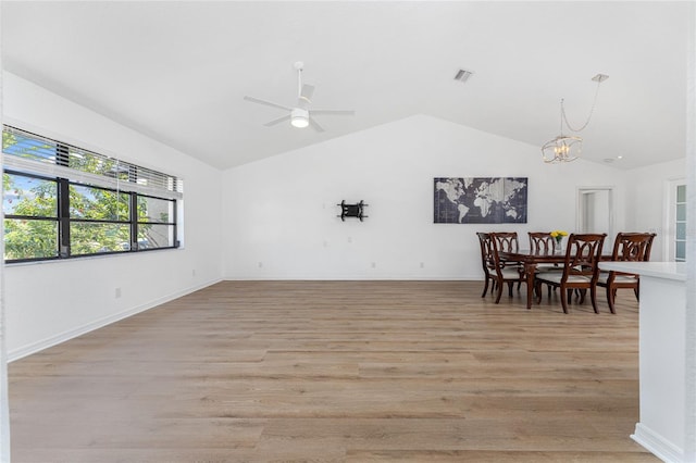 interior space featuring light wood-style floors, baseboards, visible vents, and vaulted ceiling