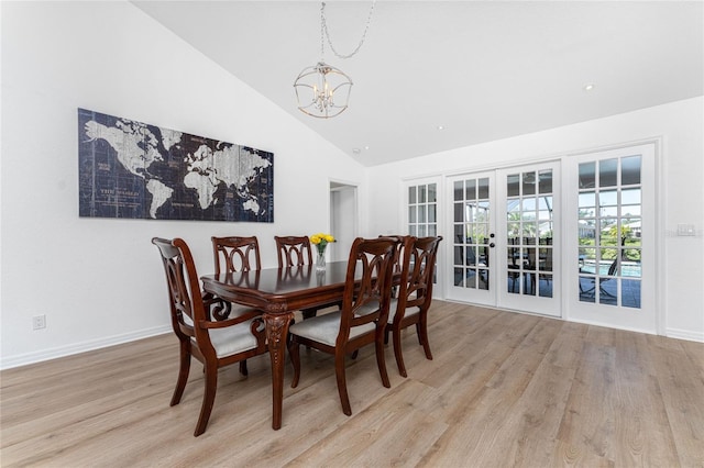 dining space featuring light wood-type flooring, french doors, a notable chandelier, and baseboards