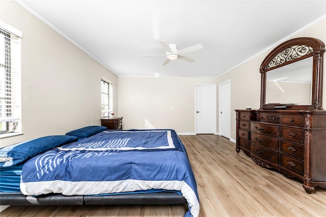 bedroom featuring light wood finished floors, baseboards, ornamental molding, and ceiling fan