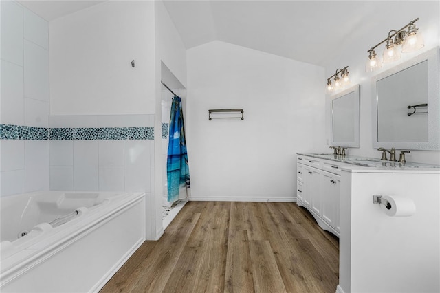 full bathroom featuring lofted ceiling, a shower with curtain, a tub with jets, wood finished floors, and vanity