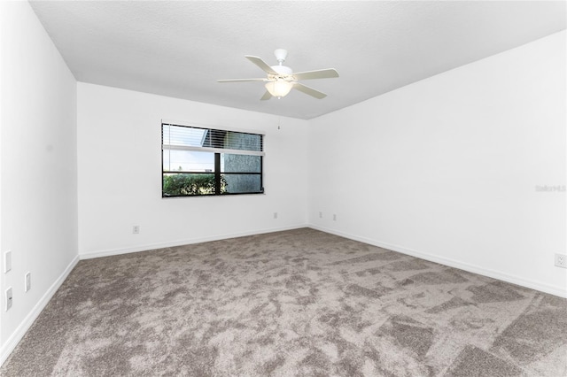 carpeted empty room with ceiling fan, baseboards, and a textured ceiling