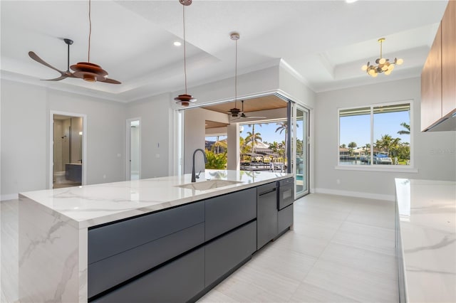 kitchen with gray cabinets, a raised ceiling, a sink, modern cabinets, and a large island with sink