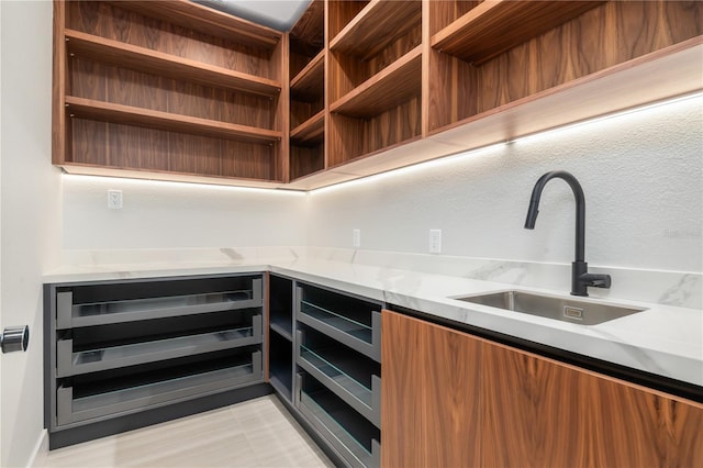 kitchen featuring beverage cooler, a sink, light countertops, open shelves, and modern cabinets