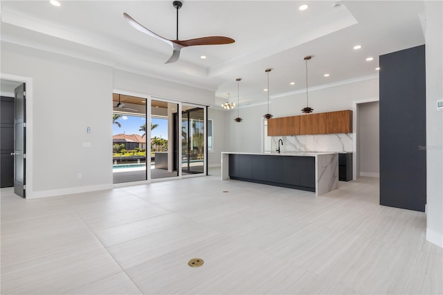 unfurnished living room with ceiling fan, a tray ceiling, baseboards, and recessed lighting