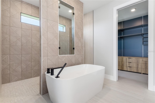 bathroom with a soaking tub, walk in shower, and tile patterned flooring