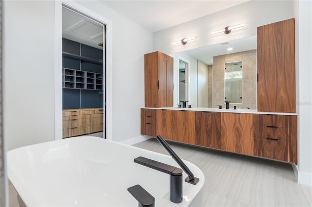 bathroom with double vanity and a freestanding tub