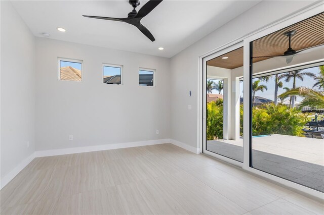 spare room with a healthy amount of sunlight, a ceiling fan, and baseboards