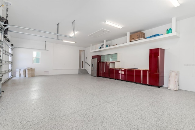 garage featuring stainless steel refrigerator with ice dispenser