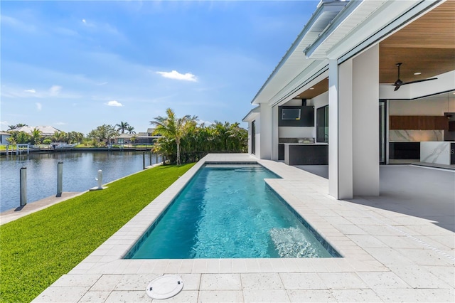 pool with a patio area, ceiling fan, a lawn, and area for grilling