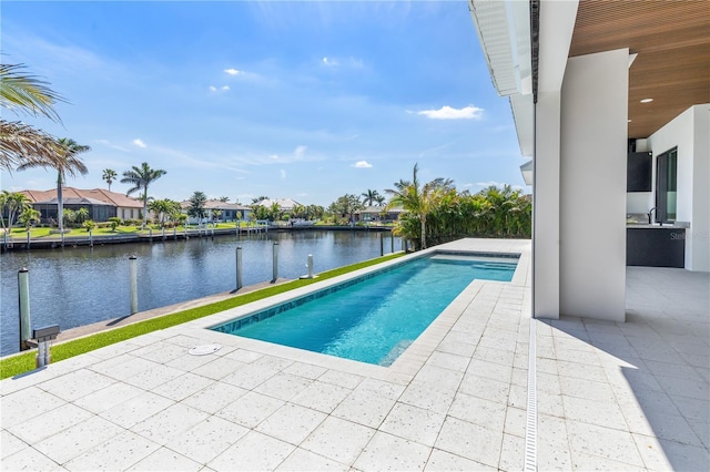 pool featuring exterior kitchen, a residential view, a patio area, and a water view