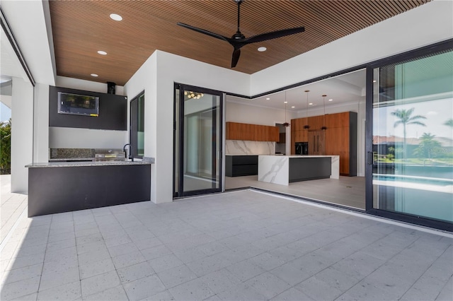 view of patio featuring ceiling fan and a sink