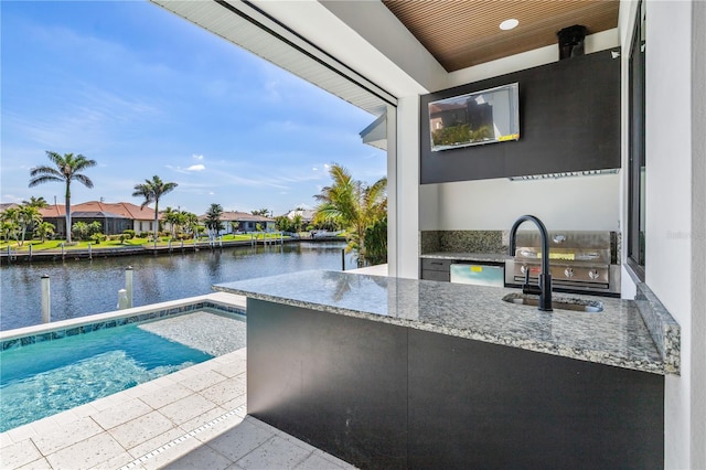 exterior space with a water view, area for grilling, a patio area, a sink, and a residential view