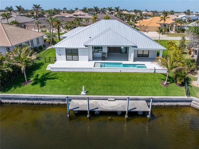 back of property with a residential view, metal roof, a patio, and stucco siding