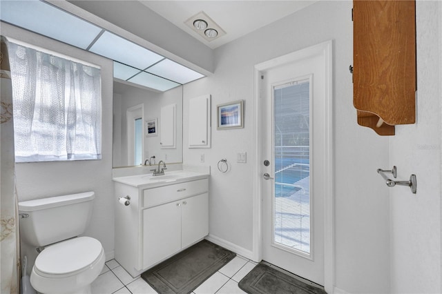 bathroom featuring tile patterned flooring, baseboards, vanity, and toilet