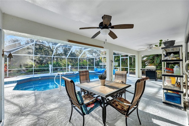 pool featuring glass enclosure, ceiling fan, area for grilling, and a patio